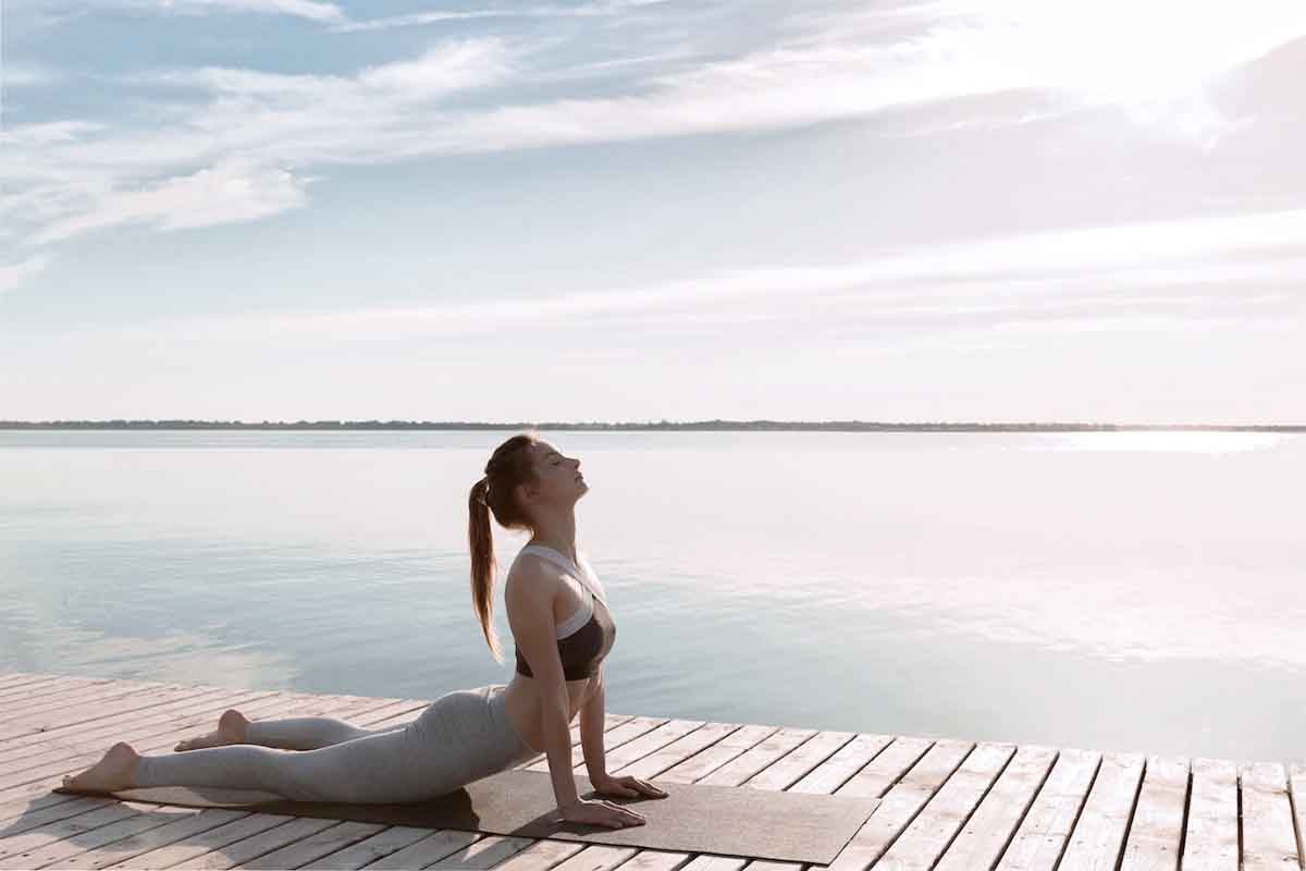 amazing-young-sports-lady-beach-make-yoga-exercises_171337-14607