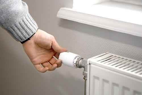 man-turning-off-radiator-during-energy-crisis