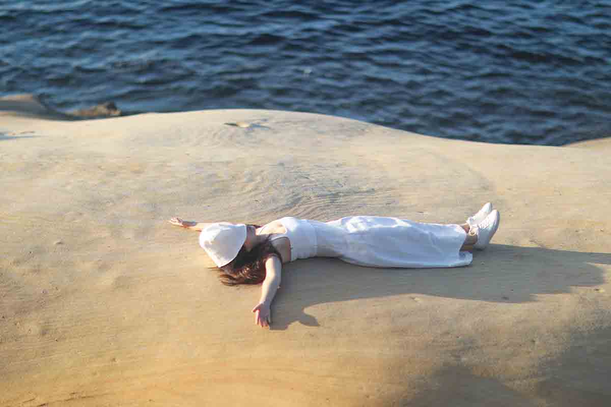 lady lying by seashore